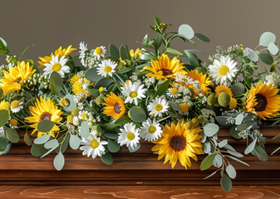 Picture of a coffin spray on a funeral casket with Sunflowers and White Daisy